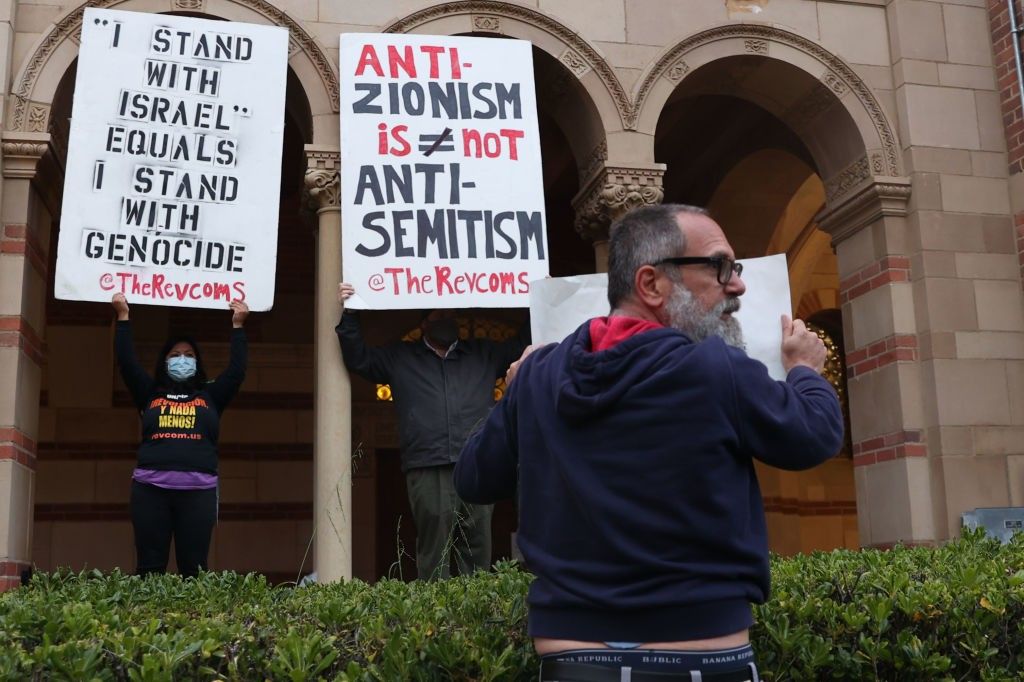 Protesters with signs including one reading "anti-Zionism does not equal antisemitism." 