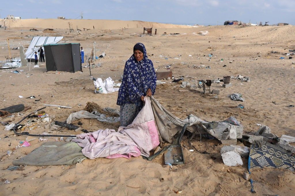 A woman folds a tent in Gaza