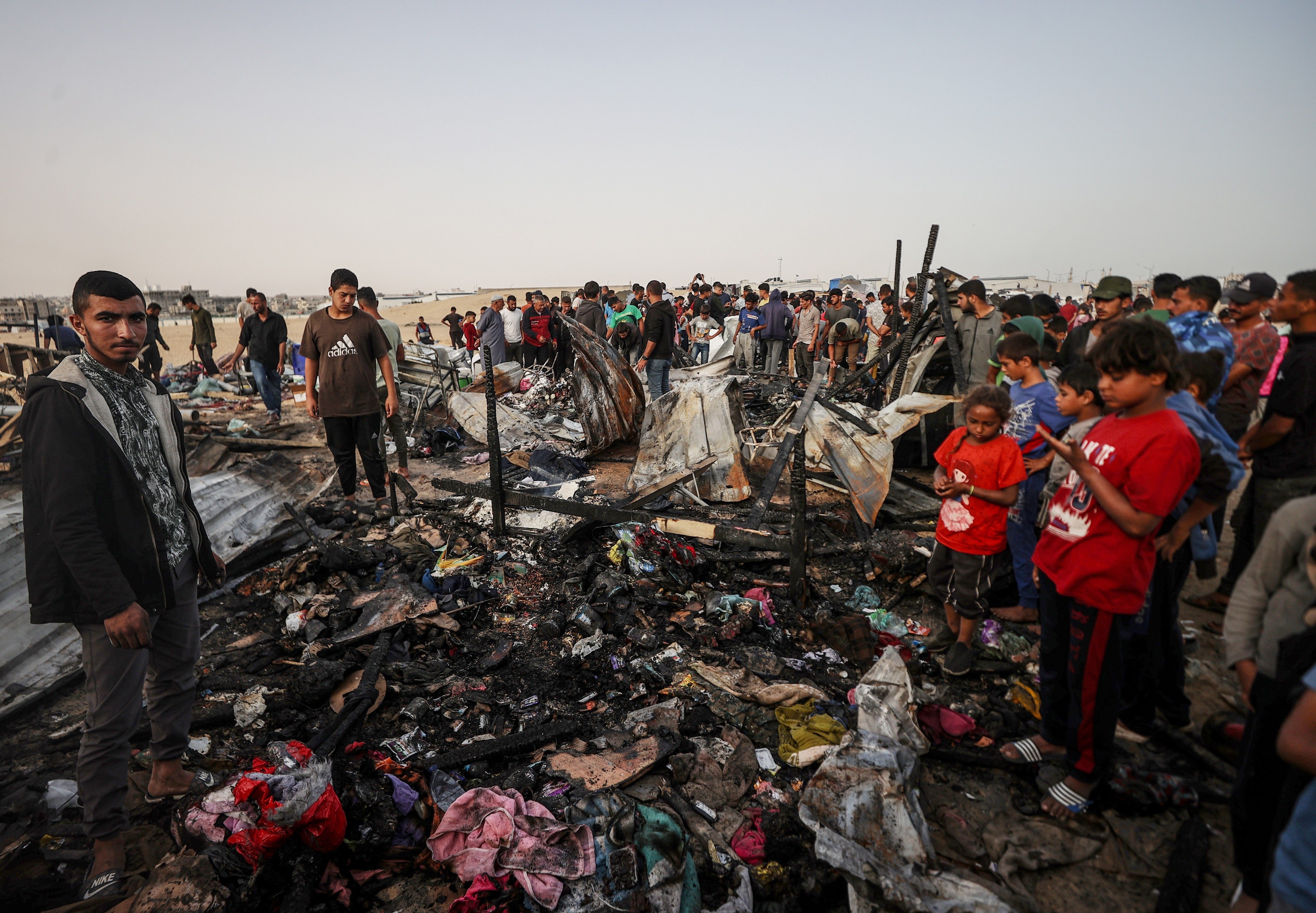 Palestinians observe the destruction caused by the Israeli military's bombing 