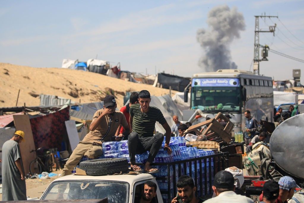 People sitting on and above vehicles as they sit in traffic in Gaza 